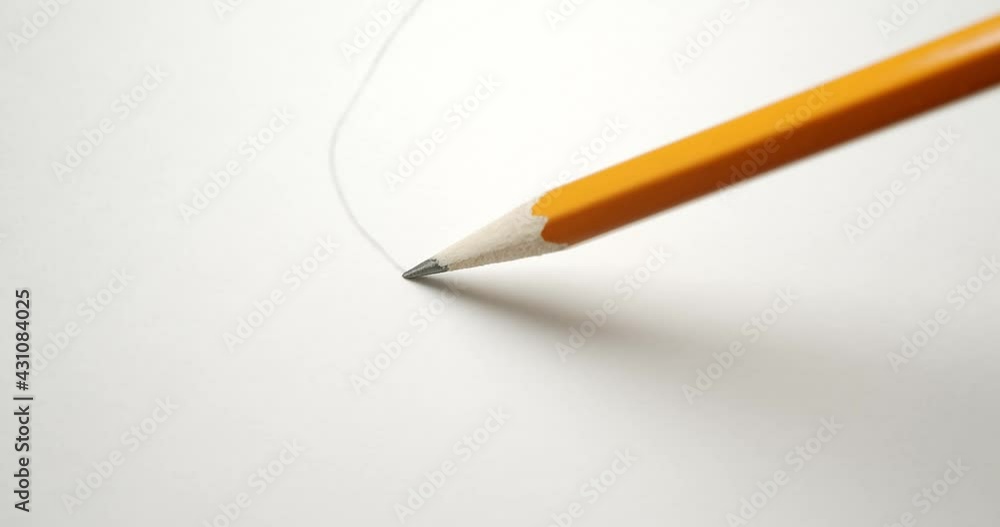 Drawing a wavy line across paper with a yellow pencil. Drawing a wavy line across paper with a yellow pencil.