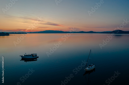 Sunrise waterscape with boats, light cloud and reflections