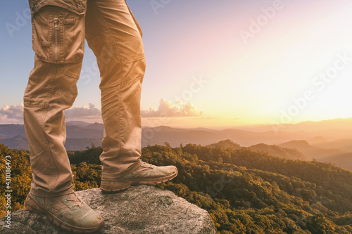 Hiker standing on top mountain sunset background. Hiker men's hiking living healthy active lifestyle.
