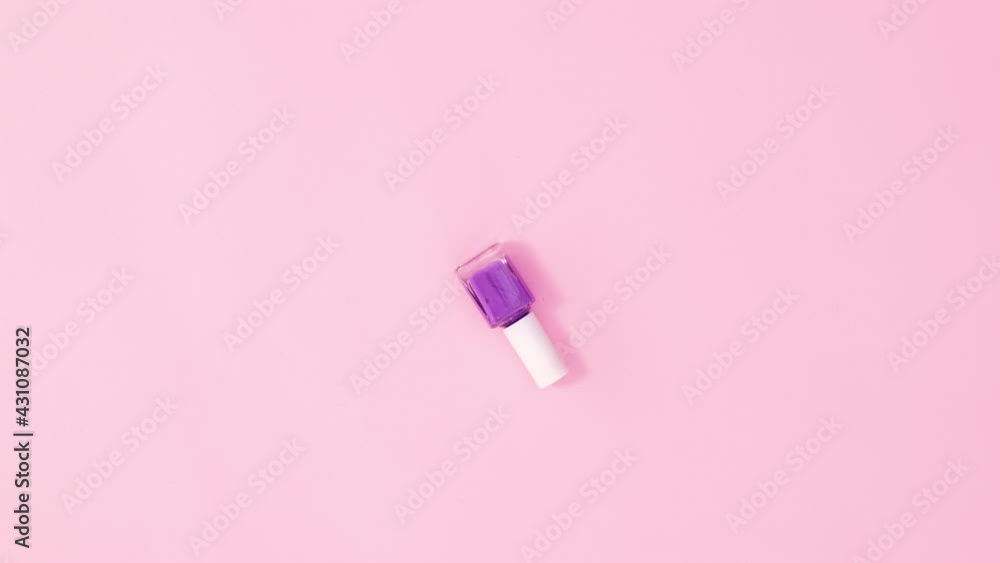 Manicure purple pink nail polish bottle rotating on pastel pink background. Stop motion flat lay Manicure purple pink nail polish bottle rotating on pastel pink background. Stop motion flat lay