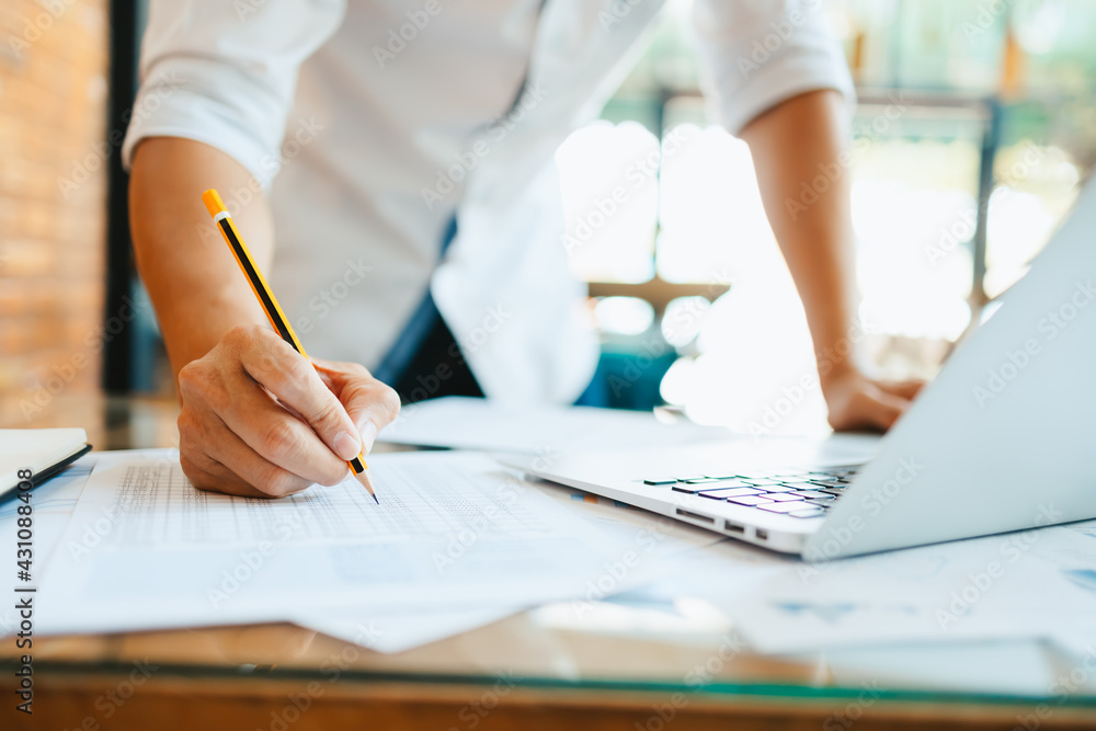 Administrator businessman making report, calculating balance. Business analyzing income charts, graphs and data on the table. Administrator businessman making report, calculating balance. Business analyzing income charts, graphs and data on the table.