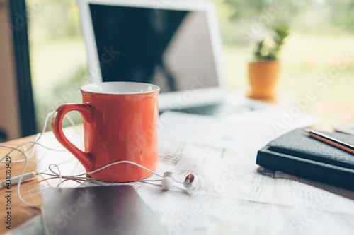 coffee cup and earphone and other travel accessories around on the table. Vocation, travel, holidays and backpack concept.