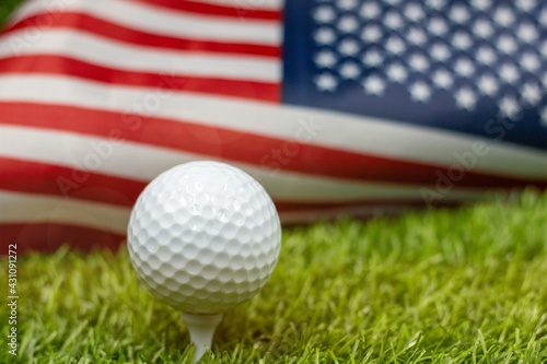 Golf ball is on American flag on green grass
