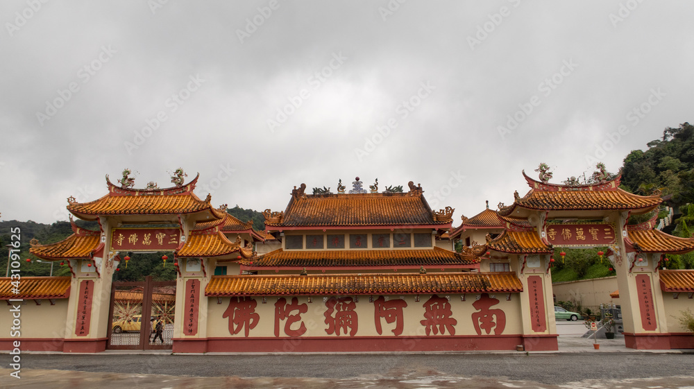 Large Buddhist temple complex with colorful gate and wall , relics, and several big gilded statues in Brinchang Malaysia 