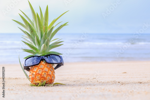 Baby pineapple wearing glasses on the Huahin beach, pineapple is traditional fruit of Prachuab Kiri Khan Thailand