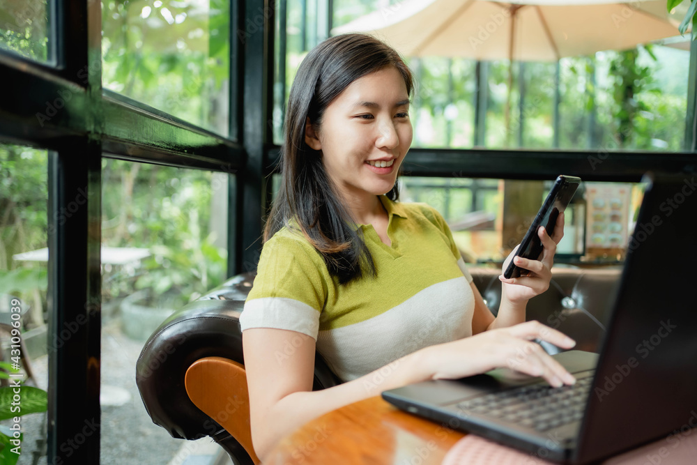 Asian women are using their laptops to work in coffee. Asian women are using their laptops to work in coffee.
