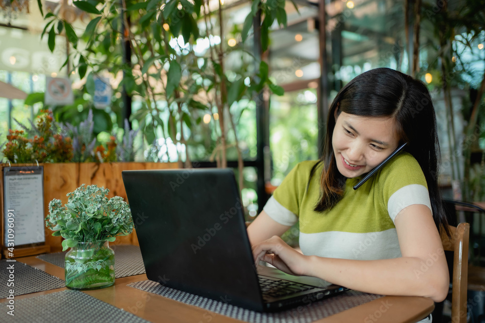 Asian women are using their laptops to work in coffee. Asian women are using their laptops to work in coffee.