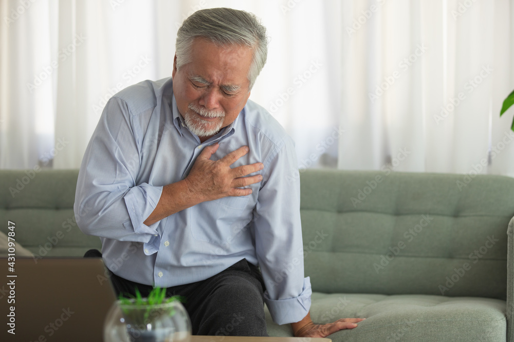 Elderly Asian man Heart pain due to heart disease in bed room. Elderly Asian man Heart pain due to heart disease in bed room.