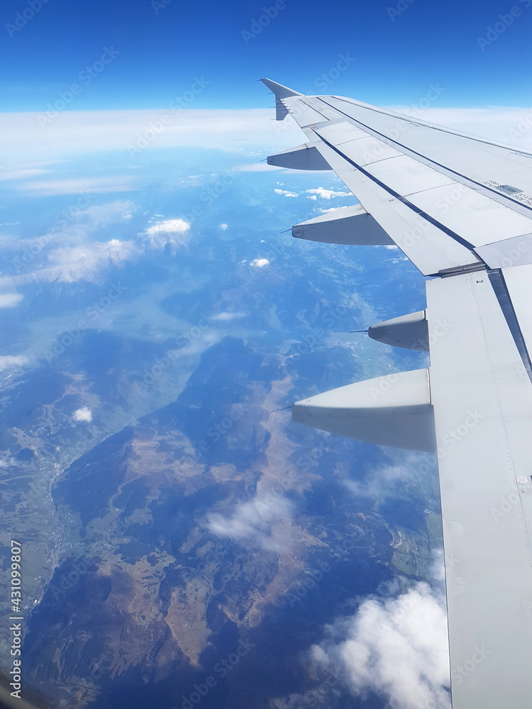Fototapeta premium Flugzeugpassagier blickt beim Fliegen in Urlaub auf Tragfläche, auch Tragflügel, Flügel. Das unter einem Bootsrumpf montierte Tragflügelboot, ist ein Bauteil für dynamischem Auftrieb.