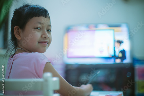 Asian little schoolgirl studying during her online lesson at home, social distance during quarantine,online education concept