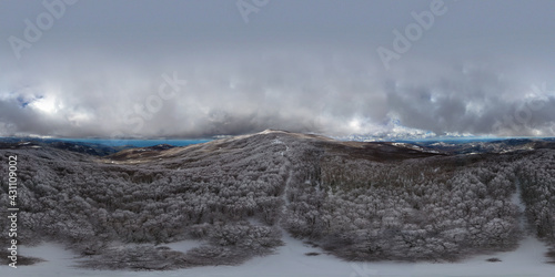 360 degrees photo of the beech forest of the Nebrodi mountains in Sicily during a light snowfall in early spring. View of Etna. Monte Soro and the Aeolian Islands with the Tyrrhenian Sea. 