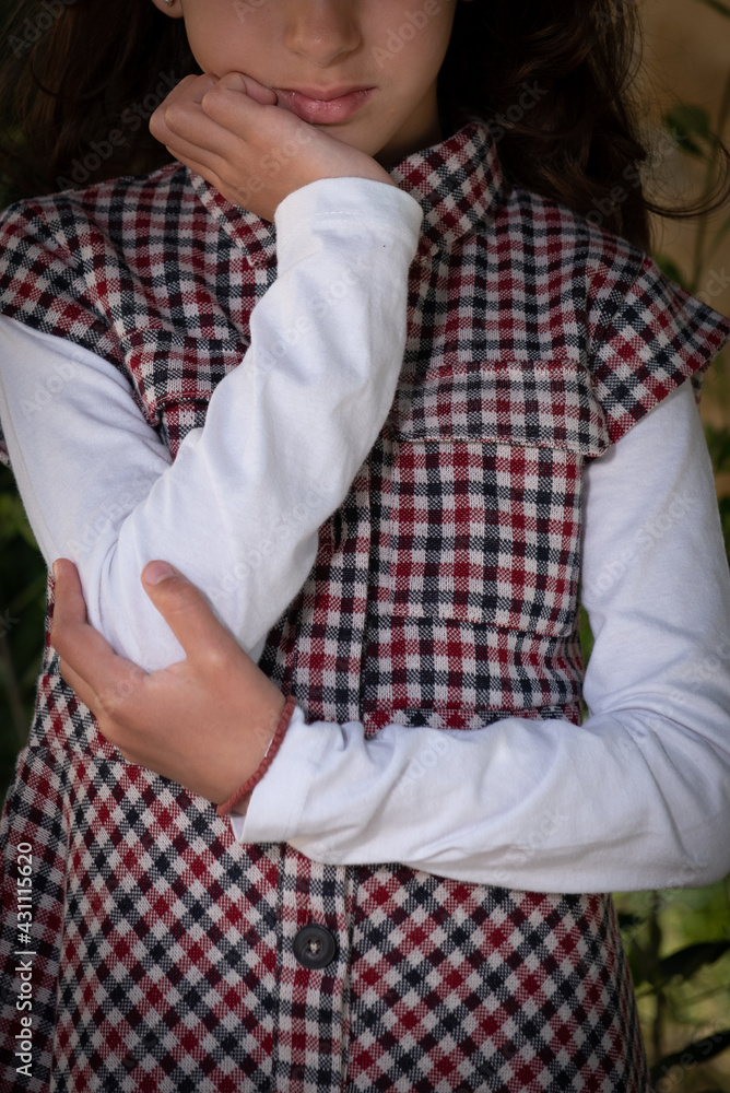 Unrecognized young girl with cross hands on her head