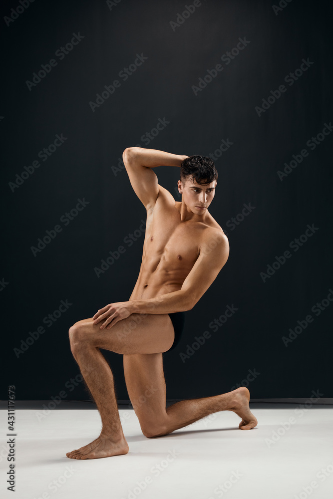 man with a pumped-up naked body posing on his knee man with a pumped-up naked body posing on his knee