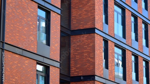 Architectural exterior detail of residential apartment building with brick facade. Modern brick and glass facade of the apartment building. © Grand Warszawski