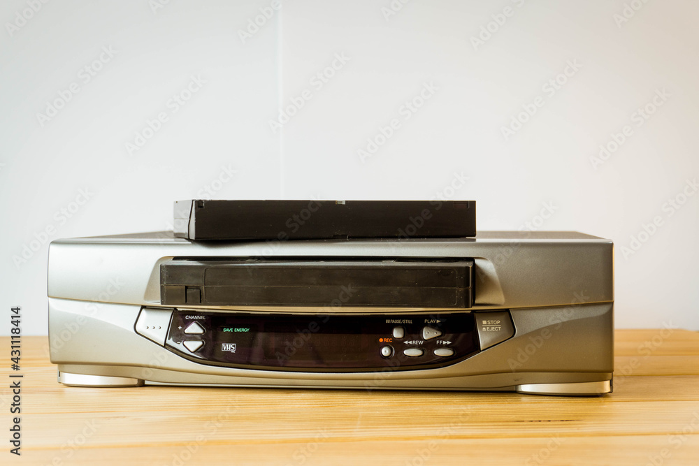 VHS player, recorder with a tape introduced and a tape on top VHS player, recorder with a tape introduced and a tape on top