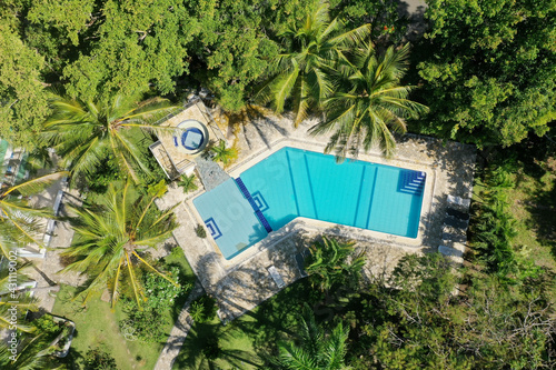 Canvas Print Aerial shot of a pool in a resort area surrounded by greenery under the sunlight