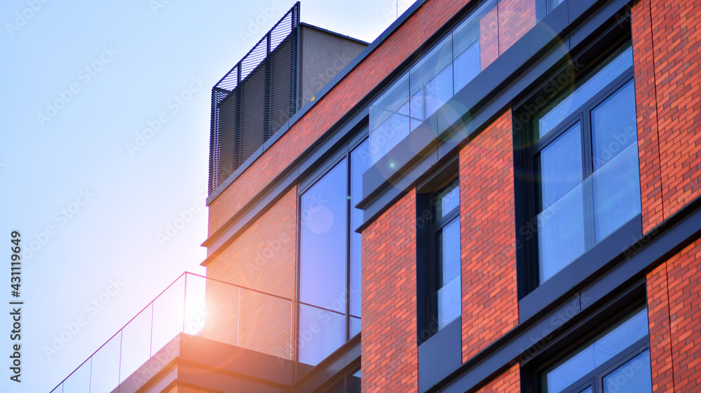 Architectural exterior detail of residential apartment building with brick facade. Modern brick and glass facade of the apartment building. Architectural exterior detail of residential apartment building with brick facade. Modern brick and glass facade of the apartment building.