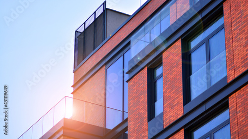 Architectural exterior detail of residential apartment building with brick facade. Modern brick and glass facade of the apartment building.