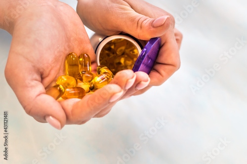 Woman holding a jar of omega 3 vitamins in her hands close up