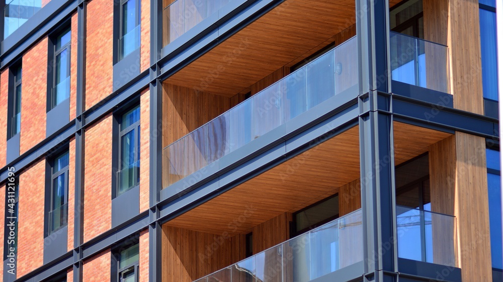 Fototapeta premium Architectural exterior detail of residential apartment building with brick facade. Modern brick and glass facade of the apartment building.