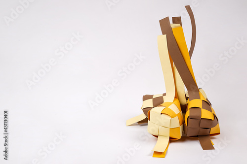 Replica of steamed diamond shaped rice made of colored cardboard isolated on white background. Steamed ketupat-shaped rice is synonymous with the month of Ramadan.