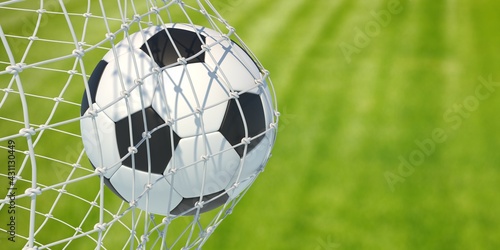 Soccer football. Soccer ball in goal net on blur green lawn background. 3d illustration