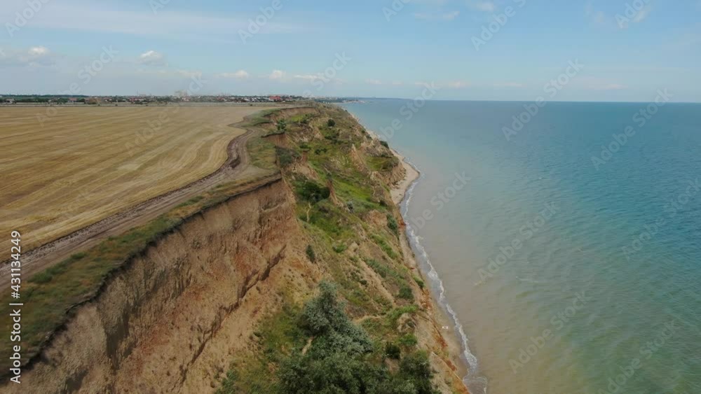 AERIAL, MOVING FORWARD: Flying over deep dangerous rocky cliffy abyss and looking down on beautiful beach with tents and sea. AERIAL, MOVING FORWARD: Flying over deep dangerous rocky cliffy abyss and looking down on beautiful beach with tents and sea.