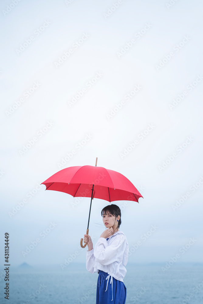雨の中で傘を差す女性