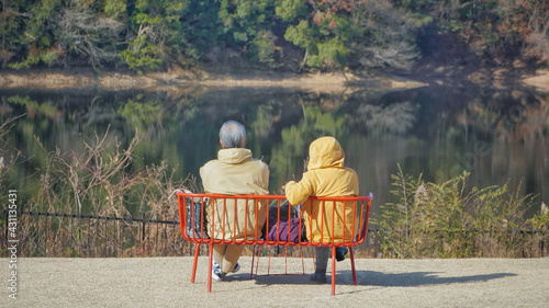 休日の湖畔のベンチの老夫婦