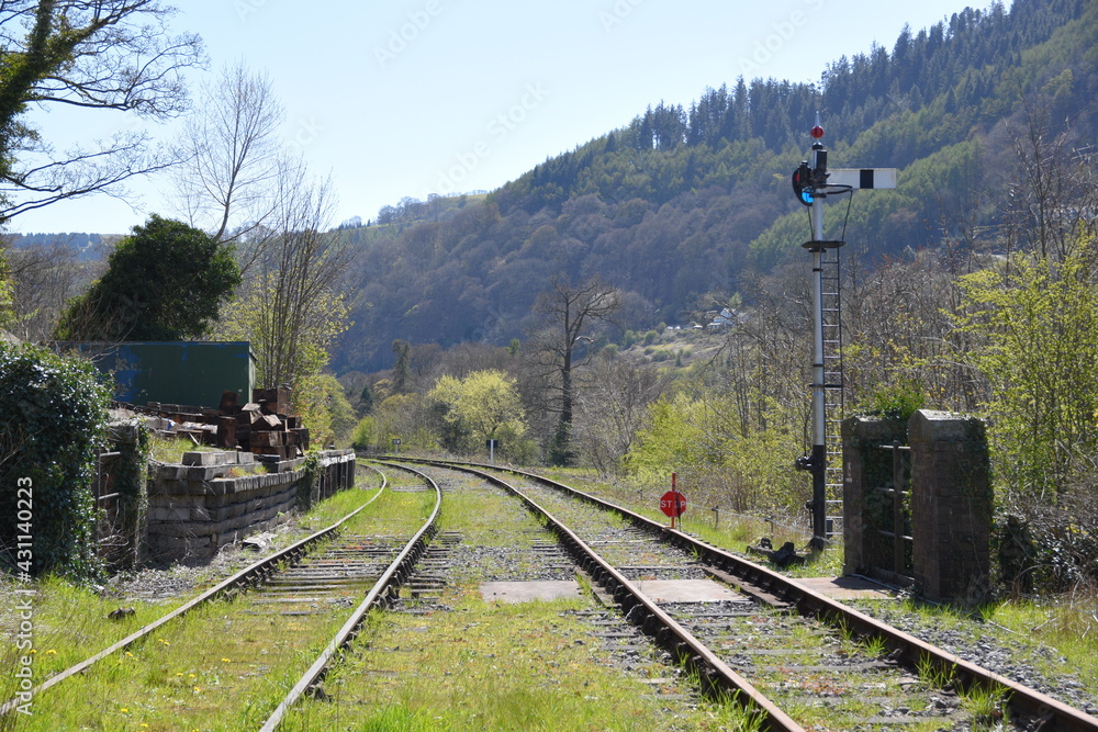 Fototapeta premium a pair of railway lines heading towards Llangollen station with signals on the side of the track