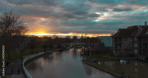 Cambridge UK January 2021 Timelapse of a sunset over the city of Cambridge. People walking by the river Cam on a cold winter day during UKs national covid lockdown