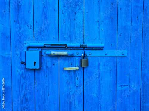 Background of vintage handle on an old wooden blue door close up. Cracked paint. Top view. 