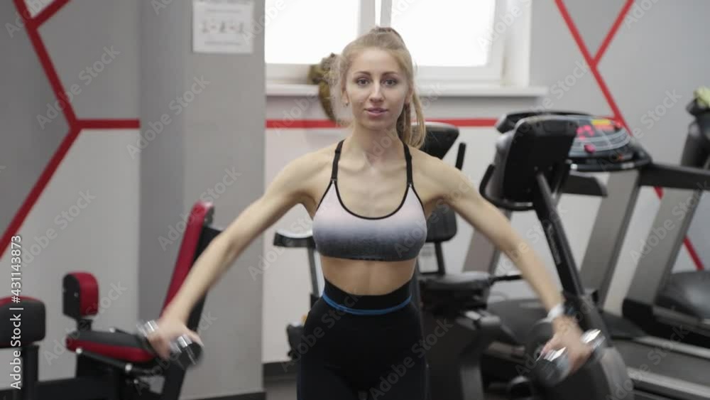 Beautiful young woman doing lifts with dumbbells. Beautiful young woman doing lifts with dumbbells.