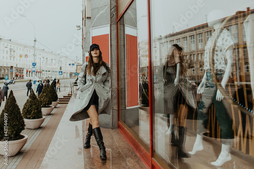 stylish girl in a trench walks around the city