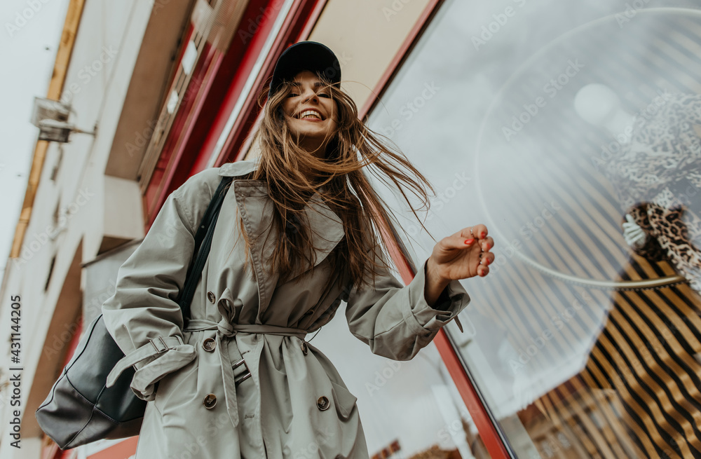 stylish girl in a trench walks around the city stylish girl in a trench walks around the city