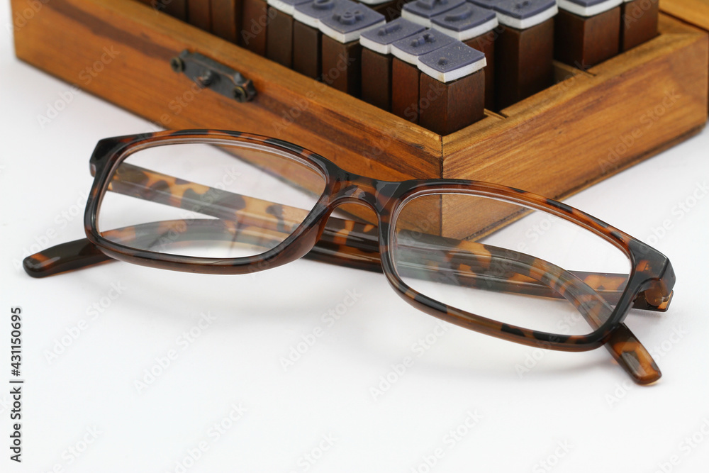 Reading glasses with vintage wooden box in the background