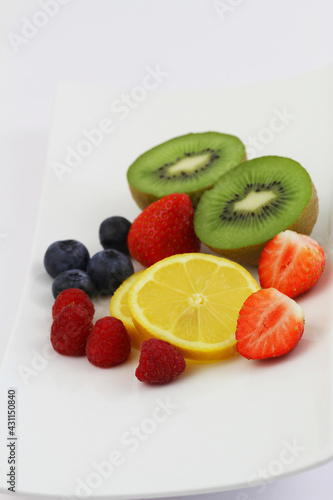Fototapeta Naklejka Na Ścianę i Meble -  Best source of Vitamin C: strawberries, bluberries, raspberries, kiwi fruit and lemon on white plate

