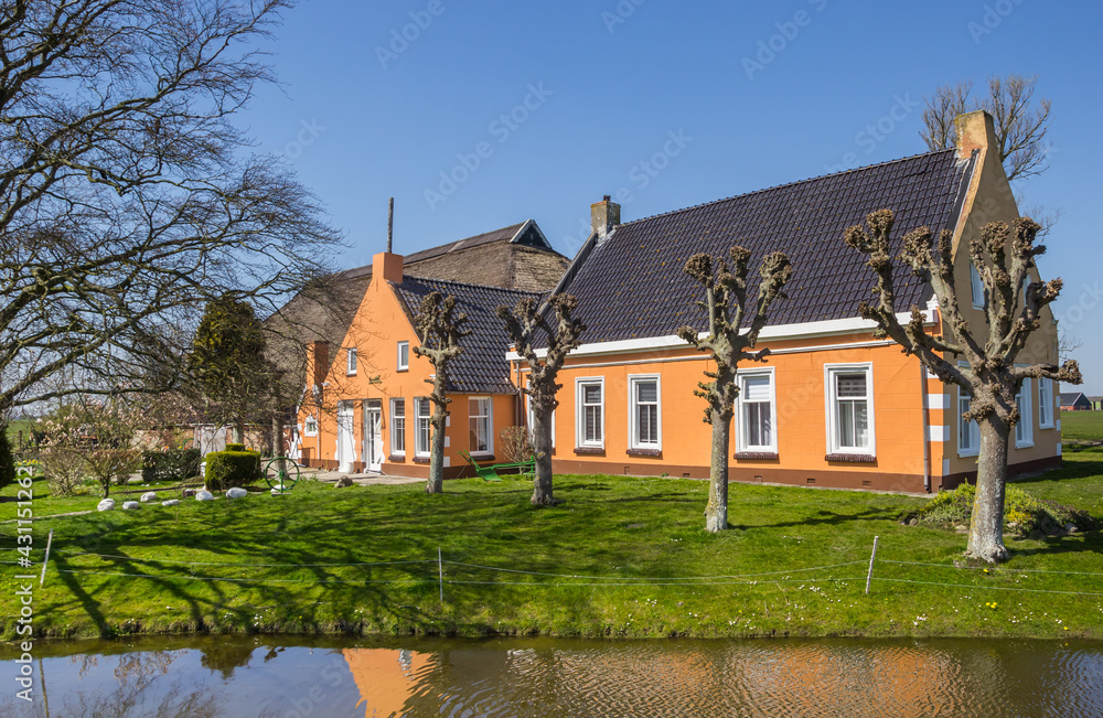 Colorful farmhouse at the water in Den Horn