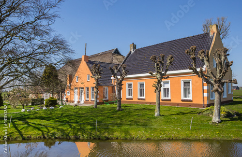 Colorful farmhouse at the water in Den Horn