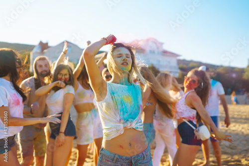 Teenagers Friends have fun at the holi festival. Beach Party. Celebrating traditional indian spring holiday. Friendship, Leisure, Vacation, Togetherness. © maxbelchenko