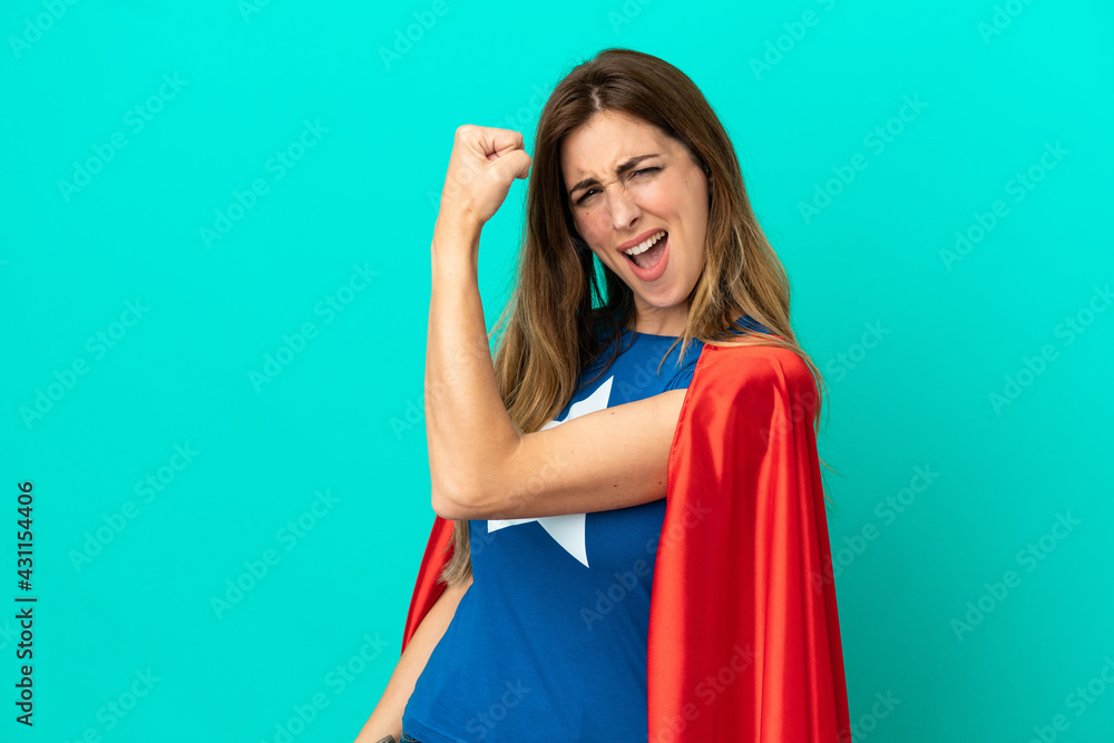 Super Hero caucasian woman isolated on blue background doing strong gesture Super Hero caucasian woman isolated on blue background doing strong gesture
