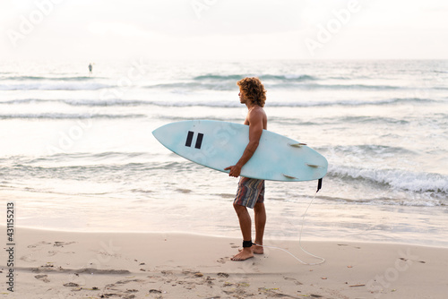 Photography Young caucasian man get up early to  doing surf at sunrise