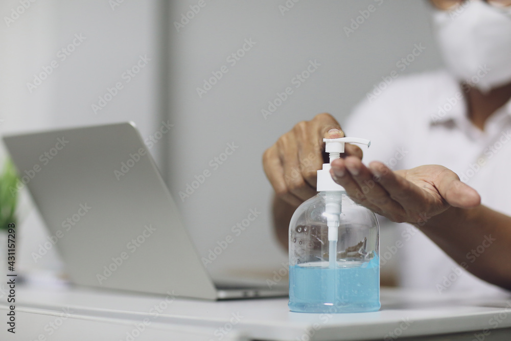 A men is pressing alcohol gel, hand sanitizer gel to clean hands, focus at the hand, working at home, the corona virus crisis event, covid19 A men is pressing alcohol gel, hand sanitizer gel to clean hands, focus at the hand, working at home, the corona virus crisis event, covid19