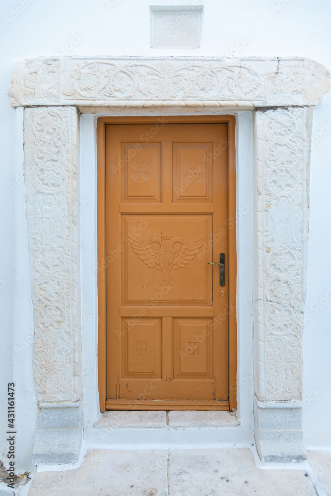 View of the white villa with brown door. Lefkes, Paros Island, Greece.