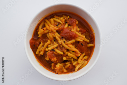 Gujarati popular side dish Sev tameta or Shev tamatar Curry homemade prepared from tomato and gramflour vermicelli. Indian cuisine food tomato vegetable gravy topped with crispy snack photo