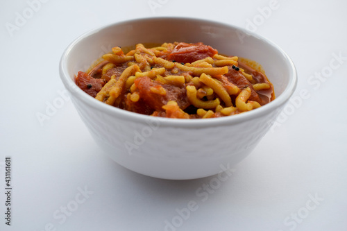 Famous and Authentic Gujarati food Sev tamatar or Sev tameta sabji made out of tomato vegetable and gramflour vermicelli. Indian side dish cuisine on white background photo