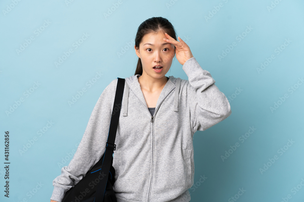 Young sport Chinese woman with sport bag over isolated blue background has realized something and intending the solution Young sport Chinese woman with sport bag over isolated blue background has realized something and intending the solution