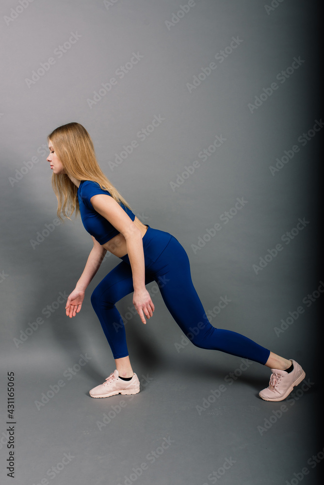 Studio photo of young caucasian female athlete. Slim blonde woman wearing sportwear