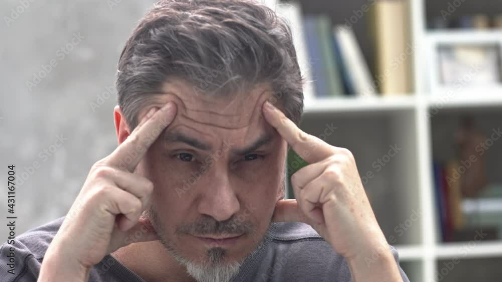 Portrait of man at home, thinking looking at camera. Serious, grey hair, beard, glasses. Portrait of mature age, middle age, mid adult man in 50s. Portrait of man at home, thinking looking at camera. Serious, grey hair, beard, glasses. Portrait of mature age, middle age, mid adult man in 50s.
