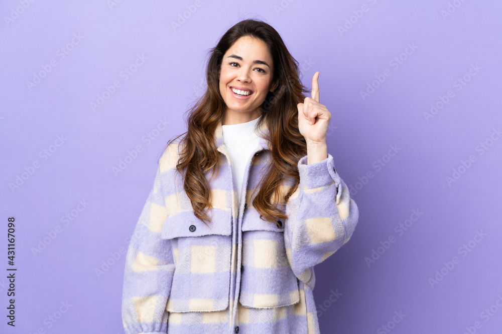 Woman over isolated purple background intending to realizes the solution while lifting a finger up Woman over isolated purple background intending to realizes the solution while lifting a finger up